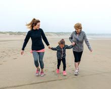 grandmother, mother and child on a beach